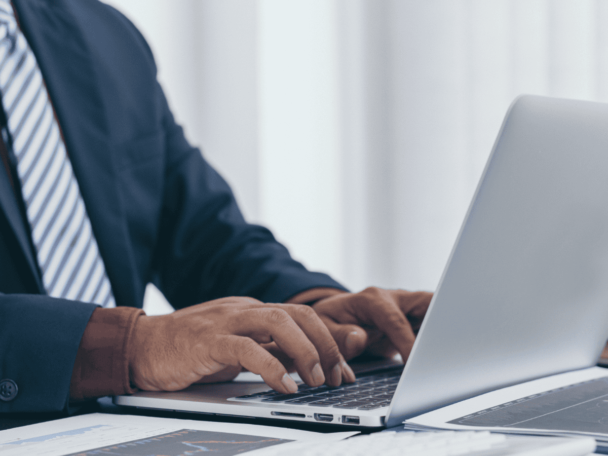 male head teacher typing on laptop