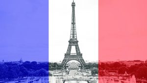 The Eiffel Tower in Paris shown against the backdrop of a French flag