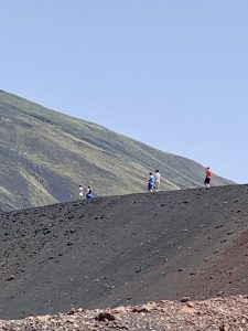 people walking up Mount Etna in daylight