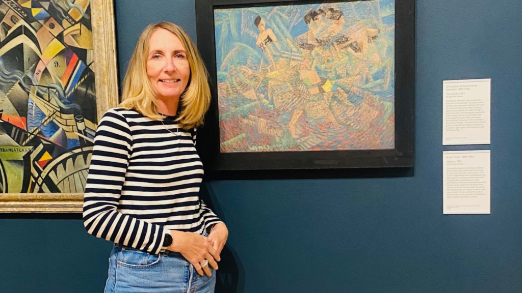 Jill standing in front of some paintings in a gallery