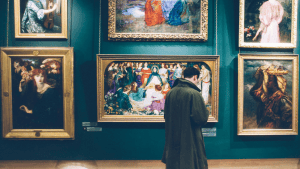 man standing in an art gallery looking at art, considering art history